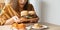 Hungry overweight woman holding hamburger on wooden plate, Fried chicken and Pizza on table .Concept of binge eating disorder BED