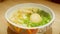 A hungry person cutting egg with a spoon. Yellow yolk flowing out of boiled egg in a japanese ramen soup. Asian noodles