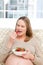 Hungry pregnant woman eating strawberries-