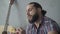 Hungry street musician eating outdoors in underground crossing. Close-up portrait of poor young Caucasian man with