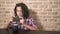 Hungry teen boy eats in the kitchen and uses a smartphone.