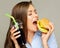 Hungry woman eating burger with cola drink.