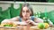 Hungry young girl on diet making choice between fast food and fresh fruits medium close-up