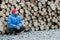 Hunkering worker having a rest at pile of logged