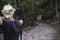 hunter with an arrow aimed at a spotted deer on a narrow mountain path.