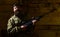 Hunter, brutal hipster with gun prepare rifle for hunting, copy space. Huntsman concept. Man with beard wears camouflage