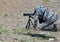 Hunter in camouflage suit looks through telescope