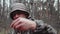 Hunter forest ranger in camouflage suit eats canned mushrooms from jar. Man with mustache in panama hat. Strange