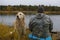 A hunter with a gun and a dog. Autumn duck hunting. Golden Retriever