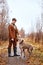 hunter guy with beautiful strong dog of Weimaraner breed on early autumn landscape