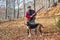 Hunter and hunting dog chasing in the forest.