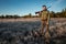 Hunter man in camouflage with a gun during the hunt in search of wild birds or game on the background of the autumn forest. Autumn