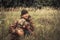 Hunter man with hunting dog Weimaraner in tall grass in rural field during hunting