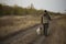 Hunter with Russian spaniel dog walking on the dirt road.