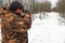 Hunter with a sniper rifle in the winter forest. A man is looking for a target