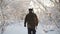 Hunter walking in the snowy winter forest. Winter hobby, sun, hunting concept.