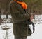 Hunter in the winter forest. Pheasant hunting at the end of the hunting season. A man holds a gun in his hands.