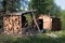 A hunting cabin and a pile of firewood nearby.