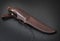 Hunting knife handmade on a black background. Leather Sheath Handmade