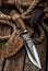 Hunting Knife with leather sheath on a wooden table.