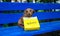 Hunting red dog dachshund holds a paper bag with the inscription - Delivery sitting on a wooden bench in a summer park.