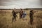 Hunting scene with hunters aiming during hunting season in rural field in overcast day with moody sky