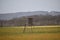 Hunting tower in a forest hunter wild hide wooden high watch post tower. Observation point of a hunter in a forest in Europe.