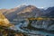 Hunza river flowing through Karakoram mountain range against clear blue sky.