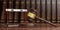 Hurdle and judge gavel against books background, 3d illustration.