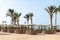 Hurghada / Egypt - July 20, 2019: Sandy beach with palm trees and parasols in Golden Beach / Movie gate resort