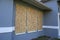 Hurricane shutters made from plywood mounted for protection of house windows. Protective measures before natural