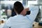 This really hurts. Rearview shot of a young businessman experiencing neck pain while working in an office.