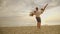 The husband circles his wife in his arms. Against the background of the sea and sunset. Happy Honeymoon