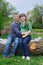 Husband and his pregnant wife sitting on a wooden deck