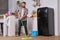 Husband housekeeper cleans the kitchen. Young happy man with green mop washes the floor