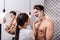 Husband laughing while his wife putting shaving foam on his face