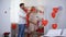 Husband leading blindfolded with red ribbon pregnant lady into decorated room