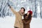 Husband Pointing Finger Up Showing Wife Something In Snowy Forest