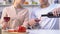 Husband pouring wine into glasses and giving to wife, couple cooking together