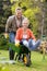 Husband pushing wife in a wheelbarrow