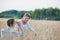 Husband taking photo of his wife in wheat field