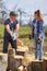 Husband teaching wife to split logs with an axe