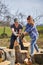 Husband teaching wife to split logs with an axe