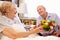 Husband Visiting Senior Wife In Hospital With Flowers