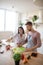 Husband and wife adding olive oil to vegetable salad