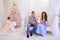 Husband and wife give each other Christmas gifts in bright spaci