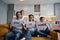 Husband, wife and son with paper signs on sofa