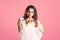 Hush, pize size model in white dress shows shh sign, fat woman having secret, pink background