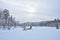 A husky dog sled carrying a sleigh with people in a snowy forest