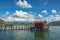 A hut on the end of a wooden pier on a lake with green reeds und